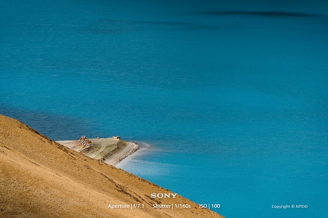Rugged mountain landscape with steep rocky terrain and dramatic lighting, showcasing the harsh beauty of Tibetan highlands