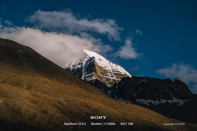 Mystical Mount Kailash emerging from swirling clouds, surrounded by ethereal Himalayan landscape with dramatic sky