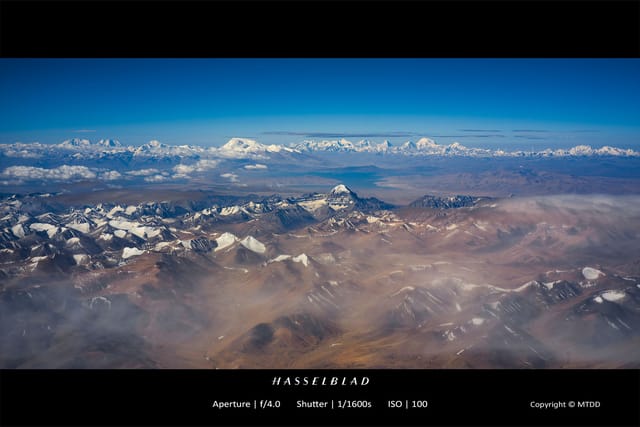 Snow-capped Himalayan mountain range with rugged peaks rising above misty valleys